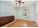 This cozy bedroom features hardwood floors, a window letting in natural light, and a classic ceiling fan at 5329 Glenbrier Dr, Charlotte, NC 28212