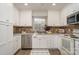 Well-lit kitchen with white cabinets, stainless steel appliances, and tiled backsplash, designed for functionality and style at 5329 Glenbrier Dr, Charlotte, NC 28212