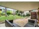 Covered patio featuring wicker seating and view of the grassy, tree-lined backyard at 5329 Glenbrier Dr, Charlotte, NC 28212