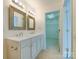 Bathroom featuring a double vanity, framed mirrors, and neutral tile flooring at 5430 Dockery Dr, Charlotte, NC 28209