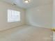 Clean bedroom with neutral carpet, a window for natural light, and fresh white walls at 5430 Dockery Dr, Charlotte, NC 28209