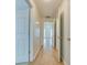 Hallway showcasing hardwood floors, white doors with gold hardware, and an open view of the front entryway at 5430 Dockery Dr, Charlotte, NC 28209