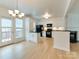 Modern kitchen with white cabinets, black appliances, and hardwood floors at 5430 Dockery Dr, Charlotte, NC 28209