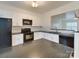 Well-appointed kitchen with white cabinets, black appliances, under cabinet lighting and sleek countertops at 5430 Dockery Dr, Charlotte, NC 28209