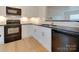 Modern kitchen with white cabinets, sleek black countertops, and updated appliances for a stylish cooking space at 5430 Dockery Dr, Charlotte, NC 28209