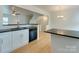 This modern kitchen boasts white cabinetry, black countertops and appliances, and an open-concept design at 5430 Dockery Dr, Charlotte, NC 28209