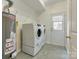 Convenient laundry room featuring modern appliances, ample storage, and an adjacent door to the outside at 5430 Dockery Dr, Charlotte, NC 28209