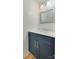 Chic powder room featuring a navy vanity with gold hardware, white countertop, framed mirror, and modern lighting at 5430 Dockery Dr, Charlotte, NC 28209