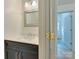 Stylish powder room featuring a dark vanity with white countertop, framed mirror, and modern lighting at 5430 Dockery Dr, Charlotte, NC 28209