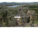 Aerial view showcasing the property's location near a lake surrounded by lush greenery at 676 Chapel Hill Dr, Troy, NC at 676 Chapel Hill Dr, Troy, NC 27371