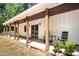 Comfortable back porch with a ceiling fan, wooden beams and rocking chairs at 676 Chapel Hill Dr, Troy, NC 27371
