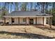 Rear exterior featuring a covered porch with timber pillars, offering a relaxing outdoor space at 676 Chapel Hill Dr, Troy, NC 27371