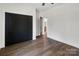 Bedroom features wood-look flooring, black closet doors, and neutral walls at 676 Chapel Hill Dr, Troy, NC 27371