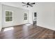 Light-filled bedroom with hardwood floors, two windows, and a view of the ensuite bathroom at 676 Chapel Hill Dr, Troy, NC 27371