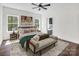 This bedroom features hardwood floors, a ceiling fan, large windows, and a cozy bench at 676 Chapel Hill Dr, Troy, NC 27371