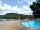 Community pool with lounge chairs overlooking a scenic lake and mountain view at 676 Chapel Hill Dr, Troy, NC 27371