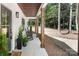 Inviting front porch with rocking chairs, wooden support columns, and stylish potted plants at 676 Chapel Hill Dr, Troy, NC 27371