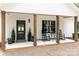 Welcoming front porch with rocking chairs, wooden columns, potted plants, and a stylish front door at 676 Chapel Hill Dr, Troy, NC 27371