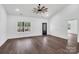 Bright living room with a ceiling fan and large window overlooking a treed lot at 676 Chapel Hill Dr, Troy, NC 27371