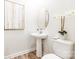 Elegant powder room featuring a pedestal sink, decorative mirror, and stylish orchid arrangement, adding a touch of sophistication at 7001 New Town Rd, Waxhaw, NC 28173