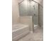 Luxurious bathroom with a glass-enclosed shower, a soaking tub, and marble-look tile at 7001 New Town Rd, Waxhaw, NC 28173