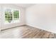 Sunlit bedroom boasts hardwood floors and a large window with a pleasant view, creating a cozy atmosphere at 7001 New Town Rd, Waxhaw, NC 28173