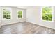 Inviting bedroom featuring ample natural light from two windows and modern hardwood flooring at 7001 New Town Rd, Waxhaw, NC 28173