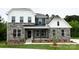 Charming two-story home with stone accents, white siding, a covered porch, and a well-manicured lawn at 7001 New Town Rd, Waxhaw, NC 28173