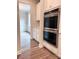 Gourmet kitchen featuring stainless steel double ovens, white cabinets, and views to the dining area at 7001 New Town Rd, Waxhaw, NC 28173