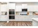 Modern kitchen featuring white cabinets, stainless steel appliances, and sleek countertops at 7001 New Town Rd, Waxhaw, NC 28173