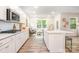 Bright kitchen with white cabinets, a kitchen island, and an adjoining living area at 7001 New Town Rd, Waxhaw, NC 28173