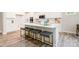 Kitchen island with gray upholstered stools, white countertop, and stainless steel sink at 7001 New Town Rd, Waxhaw, NC 28173