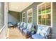 Relax on this lovely screened porch featuring cozy seating and views of the surrounding trees at 7001 New Town Rd, Waxhaw, NC 28173