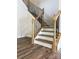 Close up of a staircase with wood and black metal spindles and white risers in the home's foyer at 7001 New Town Rd, Waxhaw, NC 28173