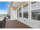 View of the wood plank balcony with gray siding, windows, and a door with neighborhood views at 7957 Reunion Row Dr, Charlotte, NC 28277
