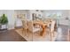 Dining room with a rustic wood table, tan upholstered chairs, a jute rug, and views into the kitchen at 7957 Reunion Row Dr, Charlotte, NC 28277