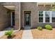 Inviting front entrance with brick facade, well-maintained landscaping, and a charming glass door at 7957 Reunion Row Dr, Charlotte, NC 28277