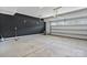 Spacious garage with a black accent wall and partially open garage door showing the outside at 7957 Reunion Row Dr, Charlotte, NC 28277