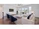 Stylish living room with hardwood floors, a patterned rug, comfortable seating, and lots of light from large windows at 7957 Reunion Row Dr, Charlotte, NC 28277