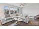Bright living room featuring hardwood floors, a large sectional sofa, and lots of windows with neighborhood views at 7957 Reunion Row Dr, Charlotte, NC 28277