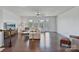 Open concept living room with hardwood floors, large windows, and a comfy seating arrangement with a flat screen TV at 7957 Reunion Row Dr, Charlotte, NC 28277