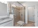 Walk-in shower featuring frameless glass, neutral tile, and a built-in shower niche at 7957 Reunion Row Dr, Charlotte, NC 28277