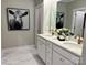 Bright bathroom featuring double sinks, white cabinets, and elegant marble-look flooring at 1030 Mapletree Ln, Indian Trail, NC 28079