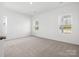 Bright bedroom with carpet flooring, white walls, and natural light from multiple windows at 1030 Mapletree Ln, Indian Trail, NC 28079