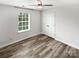 Bright bedroom with wood-look floors, a ceiling fan, and a large window at 1082 Wallace Lake Rd, Fort Mill, SC 29707