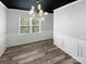 Dining room featuring an elegant light fixture, wainscoting and modern wood-look flooring at 1082 Wallace Lake Rd, Fort Mill, SC 29707