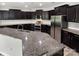 Modern kitchen with dark cabinetry, granite countertops, stainless steel appliances, and a breakfast bar at 1082 Wallace Lake Rd, Fort Mill, SC 29707