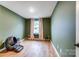 Bedroom with hardwood floors, a window seat, green walls and a robotic litter box at 1112 Drummond Ave, Charlotte, NC 28205