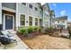 Inviting home featuring lush landscaping, gray siding, stone accents, and outdoor seating at 1112 Drummond Ave, Charlotte, NC 28205
