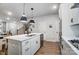 Open concept kitchen with stainless steel appliances, large island, and adjacent staircase at 1112 Drummond Ave, Charlotte, NC 28205